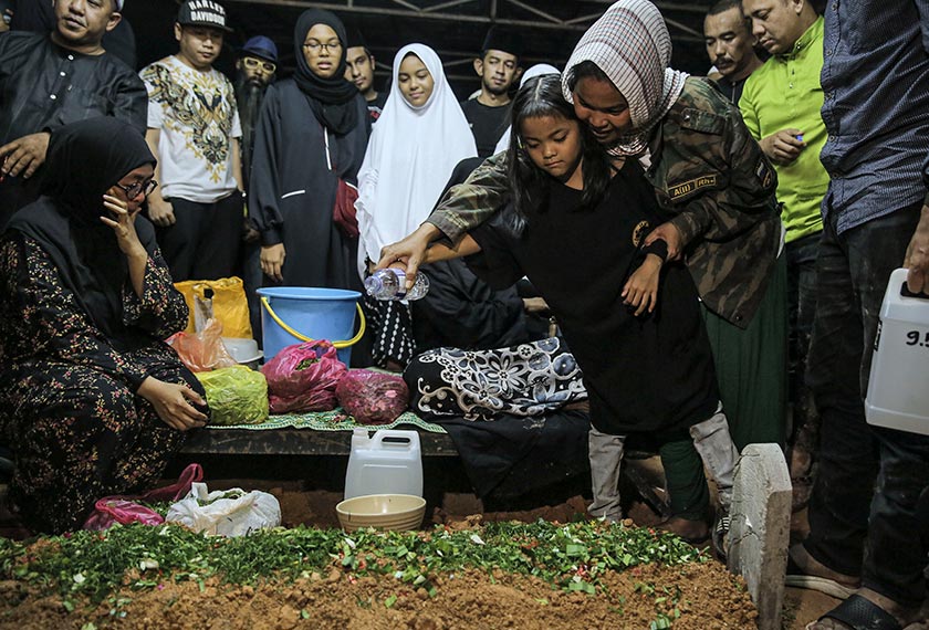 Balu Farah Ahmad bersama anak bongsu menabur bunga mawar di pusara Allahyarham.